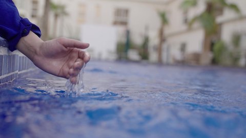 الجلوس على حدود البركة المائية ، رحلة سياحية ترفيهية ، عطلة صيفية سعيدة، تصوير مقرب ليد بنت عربيه خليجيه سعودية تضع يديها فى الماء، الاستمتاع في إحدى مسابح المملكة