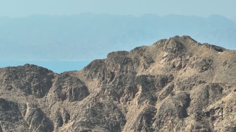 Mountain ranges in desert areas, drone photography of the terrain and rock carvings in famous historical archaeological sites in Saudi Arabia, rock formations and shapes in Wadi Tayeb Asm in the Tabuk region.