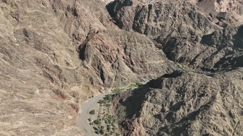 السلاسل الجبلية في المناطق الصحراوية، تصوير درون للتضاريس والنحت الصخري في الأماكن الاثرية التاريخية المشهورة في السعودية، التكوينات والتشكلات الصخرية في وادي طيب اسم في منطقة تبوك