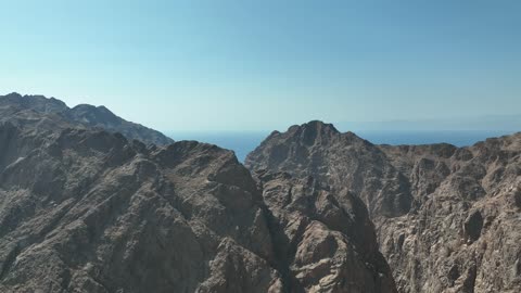 Mountain ranges in desert areas, drone photography of the terrain and rock carvings in famous historical archaeological sites in Saudi Arabia, rock formations and shapes in Wadi Tayeb Asm in the Tabuk region.