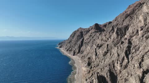 The eastern coast of the Gulf of Aqaba, areas of tourism development projects, rock formations and structures in Wadi Tayeb Asm in the Tabuk region, mountain ranges in desert areas, drone photography of the terrain and rock carvings in famous historical archaeological sites in Saudi Arabia.