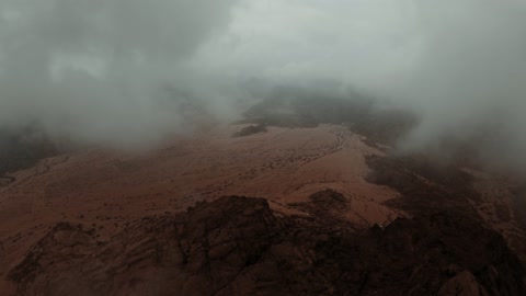 التضاريس والقمم والمرتفعات الجبلية في الصحراء، معلم أثري تاريخي قديم، تصوير درون لجبال اجا في مدينة حائل، الجبال والتكوينات الصخرية في المناطق الصحراوية في المملكة العربية السعودية في مع الضباب الكثيف،  الطبيعة الصحراوية والسياحة