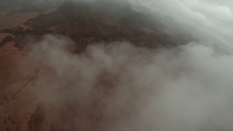 التضاريس والقمم والمرتفعات الجبلية في الصحراء، معلم أثري تاريخي قديم، تصوير درون لجبال اجا في مدينة حائل، الجبال والتكوينات الصخرية في المناطق الصحراوية في المملكة العربية السعودية في مع الضباب الكثيف،  الطبيعة الصحراوية والسياحة