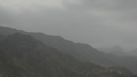 Aerial drone footage of an artist sitting in front of a musical piano and enjoying playing, musical artistic talents, the mountains of Al-Baha in the southern nature of the Kingdom of Saudi Arabia, famous tourist attractions in Riyadh, the peaks and mountainous elevations.