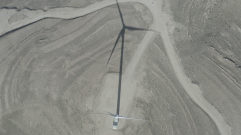 تصوير درون جوي لحقول توربينات الرياح وطواحين الهواء وسط الرمال الذهبية في المناطق الصحرواية، توليد الكهرباء بواسطة مزارع الرياح، مناخ قاسٍ وجاف، مفهوم استخدام الطاقات المتجددة صديقة البيئة، التنمية المستدامة بالطاقة البديلة في دومه الجندل بالمملكة العربية السعودية