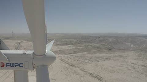 مفهوم استخدام الطاقات المتجددة صديقة البيئة، التنمية المستدامة بالطاقة البديلة في دومه الجندل بالمملكة العربية السعودية،توليد الكهرباء بواسطة مزارع الرياح، مناخ قاسٍ وجاف،  تصوير درون جوي لحقول توربينات الرياح وطواحين الهواء وسط الرمال الذهبية في المناطق الصحرواية