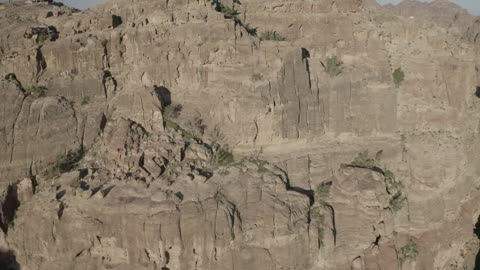 Wadi Rum in the city of Tabuk during the day, the rock formations and structures in the Hasma Desert, the desert environment and the peaks and mountain heights, tourist places in the Kingdom of Saudi Arabia, narrow valleys and natural arches and slopes, nature background.