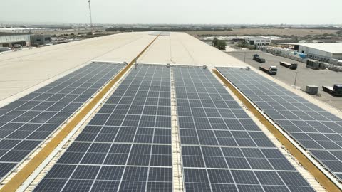 مفهوم انتاج الطاقة البديلة الصديقة للبيئة في المملكة العربية السعودية, تصوير درون جوي لمجموعة من ألواح الطاقة الكهروضوئية، انعكاس اشعة الشمس على محطات الطاقات الشمسية المتجددة