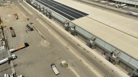 مفهوم انتاج الطاقة البديلة الصديقة للبيئة في المملكة العربية السعودية, تصوير درون جوي لمجموعة من ألواح الطاقة الكهروضوئية، انعكاس اشعة الشمس على محطات الطاقات الشمسية المتجددة