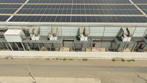 مفهوم انتاج الطاقة البديلة الصديقة للبيئة في المملكة العربية السعودية, تصوير درون جوي لمجموعة من ألواح الطاقة الكهروضوئية، انعكاس اشعة الشمس على محطات الطاقات الشمسية المتجددة