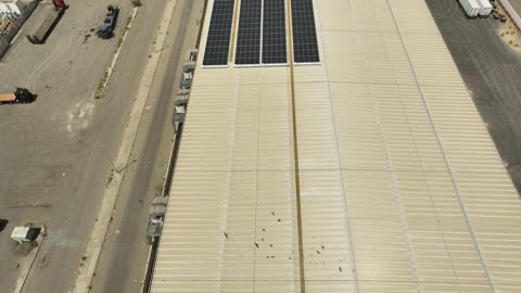 تصوير درون جوي لمجموعة من ألواح الطاقة الكهروضوئية، مفهوم انتاج الطاقة البديلة الصديقة للبيئة في المملكة العربية السعودية, انعكاس اشعة الشمس على محطات الطاقات الشمسية المتجددة