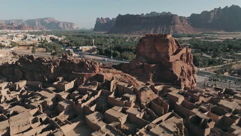 The traditional clay houses and homes, the ancient historical landmarks and areas, the peaks and mountain heights, aerial drone photography of the old village in Al-Ula Governorate in the Kingdom of Saudi Arabia, the rock formations and structures in tourist places.