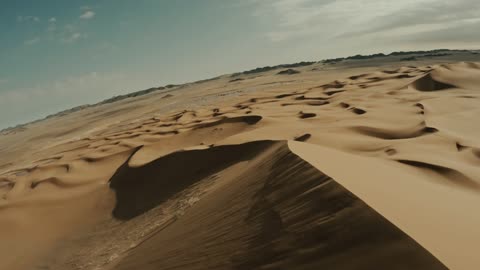 The hills and sand dunes in the Empty Quarter desert, the natural landscapes in the desert environment of the Kingdom of Saudi Arabia, formations of soft golden sands, the backdrop of the desert nature.