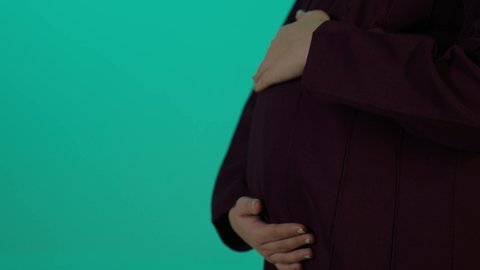 The feelings of motherhood and cradling her child inside her womb, the concept of pregnancy and childbirth, caring for the health of the fetus, maintaining her health and the health of her child, taking advantage of seasonal offers and discounts, a close-up photograph of a Saudi Arabian woman wearing an abaya and hijab with expressions of joy, blue background