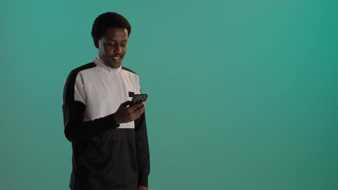 التسوق عبر الانترنت، بورتريه لطالبان توأم ذو بشرة سمراء عربيان خليجيان سعوديان يرتديان اليونيفورم المدرسىي يقومان بتصفح الهاتف المحمول، استخدام الأجهزة التقنية الحديثة، التواصل مع الأهل والاصدقاء، خلفية حضراء