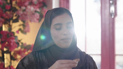 A fun outing with friends, developing social relationships, a joyful gathering on a day off, expressions of happiness and joy with companions, an upscale coffee shop in the kingdom, chatting and conversing with friends, a rear view of a Saudi Arabian Gulf woman in a hijab sitting with her friend in a restaurant.