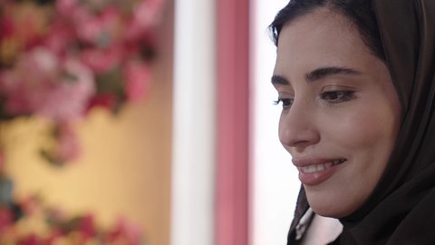 تناول المشروبات الصيفية الباردة مع الاصحاب في الهواء الطلق، التسامر والضحك بين الأصدقاء، إمرأة عربية خليجية سعودية تجلس على الاريكة في احدى الكافيهات تقضي أوقات ممتعة في عطلة نهاية الاسبوع، جلسة وناسة ونقاشات وحوارات، الاستمتاع ب المشروبات البارده