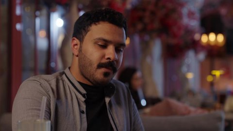 استخدام الشوكة لتناول الحلويات، قضاء أوقات ممتعة مع الاصحاب، أجواء الهدوء والاسترخاء داخل كافيه راقي، تصوير مقرب لرجل خليجي عربي سعودي يرتدي الزي الكاجوال يجلس على الكرسي يحمل بيده كأس من العصير، قضاء أوقات ممتعة في الويكند