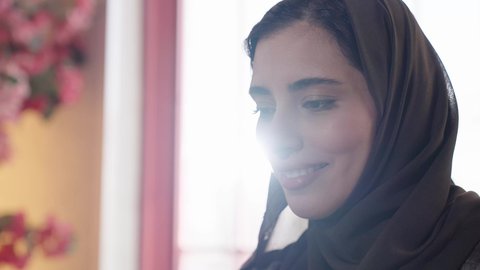 ايماءات السرور والارتواء، تناول المشروبات الصيفية الباردة في الهواء الطلق، التسامر والضحك بين الأصدقاء، إمرأة عربية خليجية سعودية تجلس على الاريكة في احدى الكافيهات تقضي أوقات ممتعة في عطلة نهاية الاسبوع، جلسة وناسة ونقاشات وحوارات، الاستمتاع ب المشروبات البارده