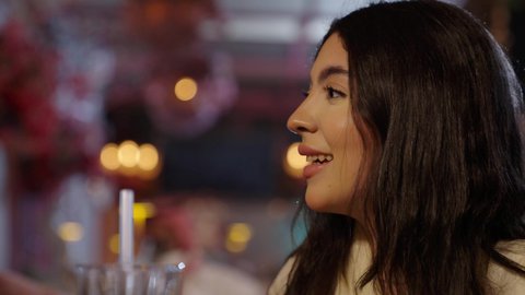 الاستمتاع بالأنشطة الترفيهية، في عطلة نهاية الاسبوع قضاء أوقات ممتعه في الخارج، تبادل الاحاديث و الدردشة مع احد الاصدقاء، تصوير مقرب لإمرأة عربية خليجية سعودية ترتدي الزي الكاجوال تقوم بتدخين الشيشة في إحدى الكافيهات, جلسة وناسة ونقاشات وحوارات