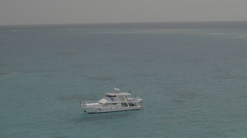 Boats and ships in the Arabian Gulf, a famous coastal area in the Kingdom of Saudi Arabia, aerial drone footage of a ship sailing in the White Island in the city of Jeddah, a recreational tourist trip in the Red Sea, a destination to attract and draw tourists from around the world.