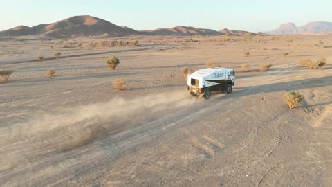 Racing on the soft golden sands, exciting challenges and recreational activities, off-roading with dirt cars in desert areas, famous competitions and events, aerial drone photography of the Dakar Rally in Saudi Arabia, World Rally Championship.