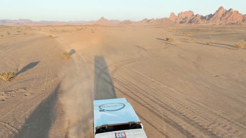 Racing on the soft golden sands, exciting challenges and recreational activities, off-roading with dirt cars in desert areas, famous competitions and events, aerial drone photography of the Dakar Rally in Saudi Arabia, World Rally Championship.