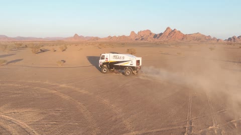 Racing on the soft golden sands, exciting challenges and recreational activities, off-roading with dirt cars in desert areas, famous competitions and events, aerial drone photography of the Dakar Rally in Saudi Arabia, World Rally Championship.