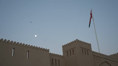 A picture of the Oman flag fluttering at Al-Hazm Fort in the city of Rustaq in the Sultanate of Oman, the historical Al-Hazm Castle, famous landmarks of Oman, architectural engineering art, forts and castles, the city of Rustaq, tourism in Oman.