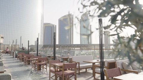 Wooden chairs and tables in a high-end cafe, cafes and restaurants serving delicious cuisine, entertainment cities and landmarks in Saudi Arabia, leisure and recreation, attracting tourists from all over the world, tourism in Saudi Arabia, a backdrop of towers and skyscrapers