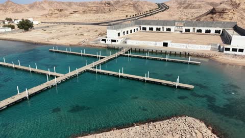 اماكن سياحية ،  معالم تبوك السياحية ، مكان رسو السفن وتوقفها في الميناء، هدوء وجمال البحر ، الواجهة البحرية في تبوك ، شاطئ محافظة حقل على سواحل البحر الأحمر في مدينة تبوك بالمملكة العربية السعودية ، تصوير درون لمرسى حقل خلال بناءه،خلفية الطبيعة البحرية