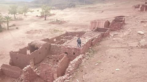 السير بين سلسلة الجبال في منطقة علقان في النهار، مناظر طبيعية للرمال الذهبية، معالم حضارية سياحية في المملكة العربية السعودية، جبال منحوتة وتشكيلات جبلية في مدينة تبوك،  تصوير درون جوي للتكوينات الصخرية في قرية بجدة نيوم غرب المملكة العربية السعودية