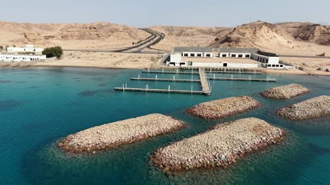 Tourist places, tourist attractions in Tabuk, a docking place for ships and their stop at the port, the tranquility and beauty of the sea, the waterfront in Tabuk, the beach of Haql Governorate on the shores of the Red Sea in Tabuk, Saudi Arabia, drone photography of Haql Marina during its construction, marine nature background.