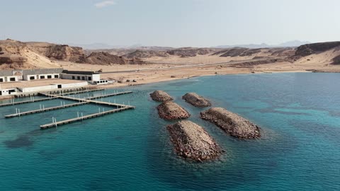 Tourism and natural landscapes, tourist attractions in Tabuk, a place for ships to dock and stop at the port, the tranquility and beauty of the sea, the waterfront in Tabuk, the beach of Haql Governorate on the shores of the Red Sea in Tabuk, Saudi Arabia, drone photography of Haql Marina during its construction, marine nature background.