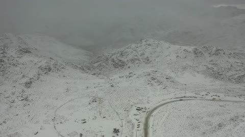 منخفض جوي، تساقط الثلوج، أجواء شتوية، معالم حضارية سياحية في المملكة العربية السعودية، سلسلة جبال اللوز في منطقة تروجينا تكسوها الثلوج، تصوير درون جوي للتكوينات الصخرية في قرية بجدة نيوم غرب المملكة العربية السعودية، جبال منحوتة وتشكيلات جبلية في مدينة تبوك