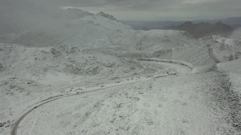 منخفض جوي، تساقط الثلوج، أجواء شتوية، معالم حضارية سياحية في المملكة العربية السعودية، سلسلة جبال اللوز في منطقة تروجينا تكسوها الثلوج، تصوير درون جوي للتكوينات الصخرية في قرية بجدة نيوم غرب المملكة العربية السعودية، جبال منحوتة وتشكيلات جبلية في مدينة تبوك