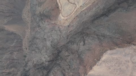 A deep gorge in the ground, a protected desert wilderness area, drone photography of the Shaqri Mountains in Tabuk, Saudi Arabia, mountain formations, Shaqri Rift, mountains and highlands, desert terrain, mountainous nature, mountain fault, natural landmarks of Tabuk.