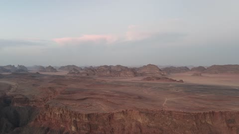 The sunlight scatters at sunrise in the sky, a protected desert wilderness area, drone photography of the Shaqri Mountains in Tabuk, Saudi Arabia, mountain formations, Shaqri crack, mountains and highlands, desert terrain, mountainous nature, mountain fault, natural landmarks of Tabuk.