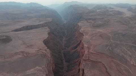 الجدران وعرة وشديدة الانحدار، تصوير درون لشق شقري في تبوك بالمملكة العربية السعودية، التكوينات الجبلية، شق شقري، الجبال والمرتفعات، التضاريس الصحراوية، الطبيعة الجبلية، صدع جبلي، معالم تبوك الطبيعية، السياحة في السعودية