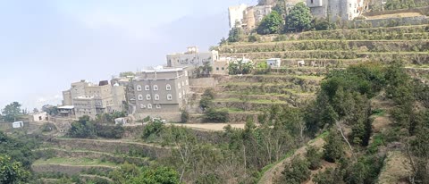 Natural tourist places and landmarks, trees and plants and areas of green nature, agricultural terraces on the mountain slopes, nature in the mountains of Faifa in Jazan, southern Saudi Arabia, peaks and rocky elevations, houses and residential buildings.