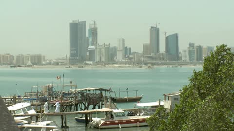 The facade of the diplomatic area in Manama, Bahrain, a panoramic shot from the fishing port in Muharraq, modern towers along the corniche, a complete urban view.