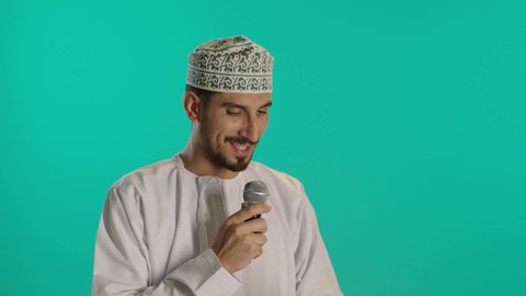 تبادل الحوار والاستفادة من خبرات،  إلقاء المحاضرات وإقامة الندوات، الدورات التدريبية و ورشات العمل,  بورتريه مقرب لرجل عربي خليجي عماني يرتدي الدشداشة والكمه  يحمل مكبر الصوت  وهاتف محمول بيده ويقوم بالنقاشات الهامة، إقامة الندوات وإلقاء المحاضرات، خلفية زرقاء