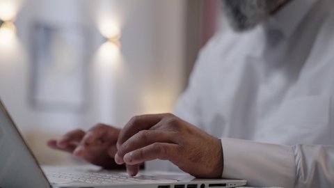 النقر على لوحة المفاتيح ، تصوير مقرب ليد رجل عربي خليجي سعودي يستخدم الحاسب المحمول، مفهوم العمل عن بعد