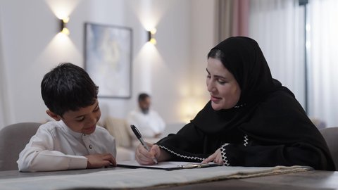 معلمة خصوصي لمتابعة الدروس في المنزل، حل الواجبات المنزليه، مفهوم الاجتهاد وطلب التفوق، تنمية المهارات الثقافية والقدرات الفكرية للابناء، أم عربية خليجة سعودية محجبة تقوم بتعليم وتدريس ابنها