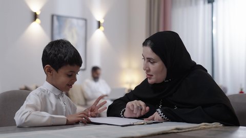 حل الواجبات المنزليه، مفهوم الاجتهاد وطلب التفوق، تنمية المهارات الثقافية والقدرات الفكرية للابناء، معلمة خصوصي لمتابعة الدروس في المنزل ، أم عربية خليجة سعودية محجبة تقوم بتعليم وتدريس ابنها