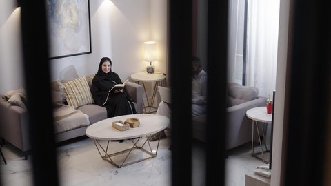 شغف المطالعة للكتب والروايات، القيام بالانشطة المسلية في المنزل، تعليم الاولاد على التثقيف والمطالعة، قضاء وقت ممتع مع الأبناء ، رجل عربي خليجي سعودي يجلس فى غرفة المعيشة برفقة زوجته و ابنه يقوم باستخدام الحاسب المحمول ، قضاء وقت ممتع مع الابناء