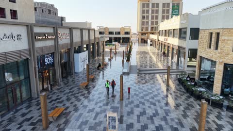 المطاعم والمقاهي والمراكز التجارية المميزة، تصوير درون لمجمع ساس بوليفارد في حي المروج بمدينة تبوك في وقت النهار، وجهة ترفيهية وتجارية حديثة، الفن الهندسي المعماري على الطراز الحديث والمتطور لمشروع جوهرة ساس في المملكة العربية السعودية