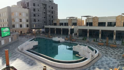 وجهة ترفيهية وتجارية حديثة، المطاعم والمقاهي والمراكز التجارية المميزة، تصوير درون لمجمع ساس بوليفارد في حي المروج بمدينة تبوك في وقت النهار، الفن الهندسي المعماري على الطراز الحديث والمتطور لمشروع جوهرة ساس في المملكة العربية السعودية