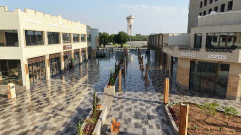 المطاعم والمقاهي والمراكز التجارية المميزة، تصوير درون لمجمع ساس بوليفارد في حي المروج بمدينة تبوك في وقت النهار، وجهة ترفيهية وتجارية حديثة، الفن الهندسي المعماري على الطراز الحديث والمتطور لمشروع جوهرة ساس في المملكة العربية السعودية