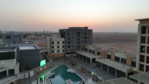 الفن الهندسي المعماري على الطراز الحديث والمتطور لمشروع جوهرة ساس في المملكة العربية السعودية، وجهة ترفيهية وتجارية حديثة، المطاعم والمقاهي والمراكز التجارية المميزة، تصوير درون لمجمع ساس بوليفارد في حي المروج بمدينة تبوك في وقت النهار